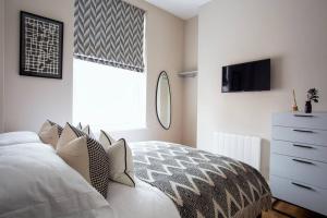 um quarto com uma cama, uma cómoda e uma televisão em Eden Apartment - Islington - 2 bed with terrace em Londres