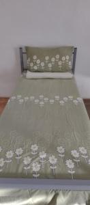 łóżko z zieloną narzutą z kwiatami w obiekcie Hostel Tulcea w mieście Tulcza