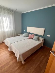 セデイラにあるApartamento en Cedeira a 3 minutos caminando a la playaの青い壁の客室の大型ベッド1台分です。