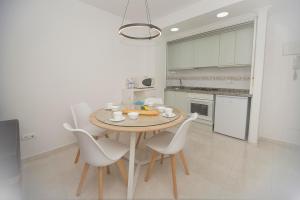uma cozinha com mesa e cadeiras num quarto em Topacio 3 en prim43ra linea de la playa en Calpe con Buenas vistas em Calpe