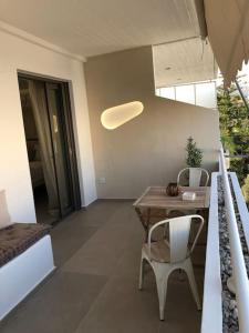 a living room with a table and chairs and a bed at Anastasia Suite/byArtistUnknown in Vari