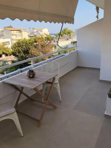 einen Balkon mit einem Tisch, Stühlen und einem Sonnenschirm in der Unterkunft Anastasia Suite/byArtistUnknown in Vari
