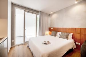 una camera da letto con un grande letto con due libri sopra di Lisbon Oriente Apartments by Olala Homes a Lisbona