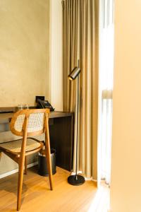 a desk with a chair and a lamp in a room at Parkhotel Waregem in Waregem