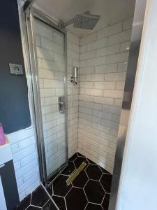 a bathroom with a shower with a black and white floor at Secret Tiny Houses in Mudanya