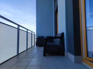 華沙的住宿－Apartamenty METRO TARGÓWEK 27，坐在大楼阳台上的椅子