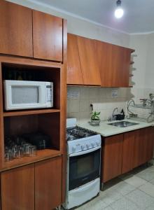 a kitchen with a stove and a microwave at Casa Alvarado Hostel in Salta