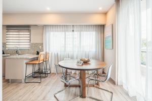 a kitchen and dining room with a table and chairs at Fully Serviced Apartment at Regatta Living II - 302 in La Julia