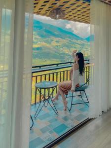 une femme assise sur une chaise sur un balcon dans l'établissement Ánh Sao Sapa Hotel, à Sa Pa