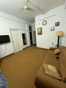 a living room with a couch and a clock on the wall at Apartment first floor for rent near commercial market satellite town Rawalpindi in Rawalpindi