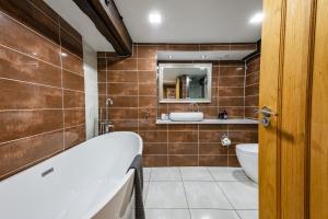 a bathroom with a tub and a sink at Spacious, luxury town centre Granary conversion in Stamford