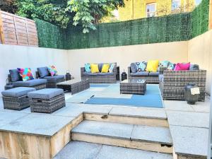 a patio with wicker couches and a fire pit at Spacious Six Bedrooms House By Sensational Stay Short Lets & Serviced Accommodation With 13 Beds, Free Parking, Free Wi-fi & Balcony in London
