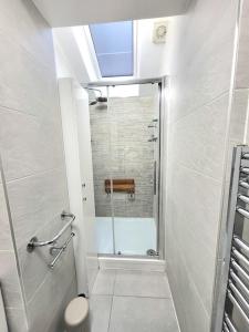 a bathroom with a shower with a glass door at Spacious Six Bedrooms House By Sensational Stay Short Lets & Serviced Accommodation With 13 Beds, Free Parking, Free Wi-fi & Balcony in London