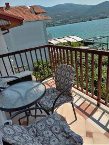 uma varanda com mesa e cadeiras e água em Orhidea House em Ohrid