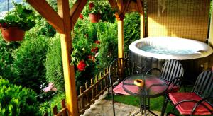 a patio with a hot tub and a table and chairs at Studio Mokos in Donji Milanovac