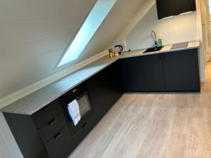 a kitchen with black cabinets and a sink and a window at Fjord apartment 