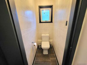 a small bathroom with a toilet and a window at Spacious Six Bedrooms House By Sensational Stay Short Lets & Serviced Accommodation With 13 Beds, Free Parking, Free Wi-fi & Balcony in London