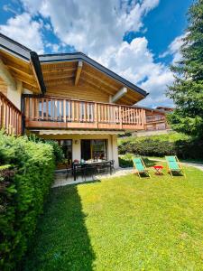 a house with a deck and two chairs in the yard at Chalet Joli-Chalet in Crans-Montana