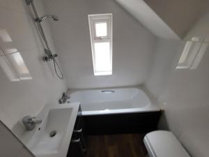 een badkamer met een wastafel, een toilet en een raam bij MM Short Stays in Birmingham