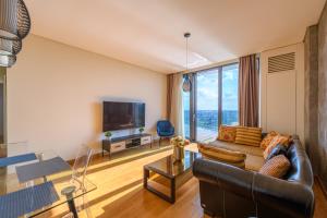 ベオグラードにあるBW Residences penthouse 2BDR with pool&gymのソファと大きな窓のあるリビングルーム