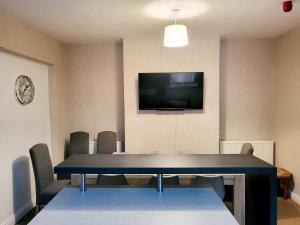 a conference room with a table and a tv on a wall at MM Short Stays in Birmingham