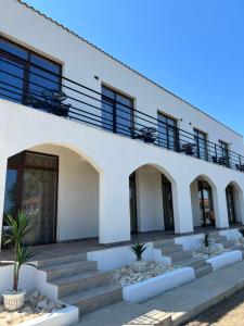 a white building with stairs in front of it at A L L E G R I A in Vama Veche