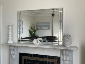 The KinBrae Apartment في توركواي: مرآة على رأس موقد في غرفة المعيشة