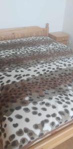 a bedroom with a bed with a leopard print blanket at Апартамент Лана in Byala