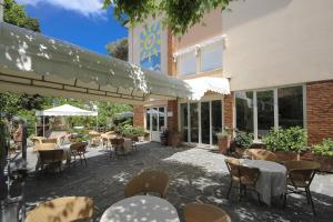 un patio con tavoli e sedie e un edificio di Hotel Miramare a Forte dei Marmi