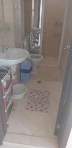 a bathroom with two toilets and a sink and a tub at Апартамент Лана in Byala