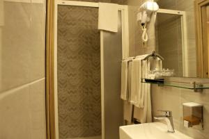 a bathroom with a shower and a sink and a mirror at Guesthouse Režekov podrum in Jastrebarsko