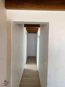 an empty hallway with white walls and a hallway with a hallway at Casa branca in Olhão