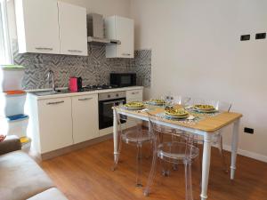 a kitchen with a table with dishes on it at Sicily Holidays Home in Calatabiano
