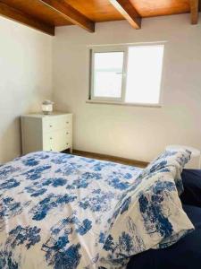 a bedroom with a blue and white bed with a window at Casa branca in Olhão