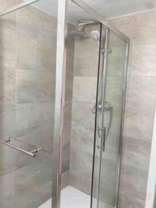 a shower with a glass door in a bathroom at Casa branca in Olhão