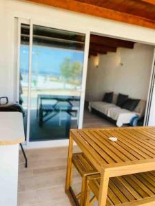 een woonkamer met een houten tafel en een balkon bij Casa branca in Olhão