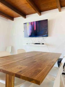 a wooden table in a room with a flat screen tv at Casa branca in Olhão