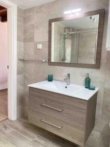 een badkamer met een wastafel en een spiegel bij Casa branca in Olhão