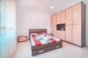 ein Schlafzimmer mit einem Bett und einem großen Schrank in der Unterkunft Mirror beach-Apartments Mecaj in (( Kalive Gjoka ))