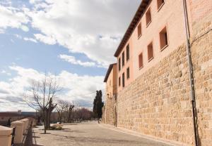 a brick wall next to a building on a street at Casa Rural EL RINCON DEL CHEF in Castrojeriz