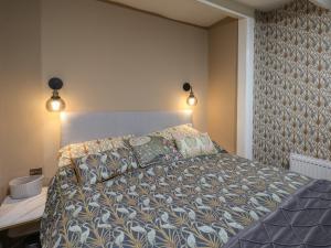 Un dormitorio con una cama y dos luces en la pared. en The Seaside House, en Saltburn-by-the-Sea