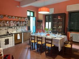 eine Küche mit einem Tisch und Stühlen im Zimmer in der Unterkunft B&B Villa Rachele in Casaletto Spartano