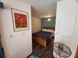 um pequeno quarto com uma cama e uma ventoinha em Caz'à Boucan em Saint-Gilles-les-Bains