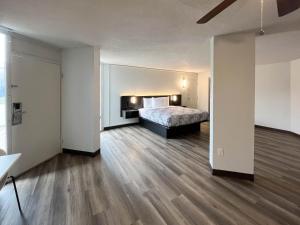 ein Schlafzimmer mit einem Bett in einem Zimmer mit Holzböden in der Unterkunft Studio 6 Nacogdoches TX SFA University in Nacogdoches