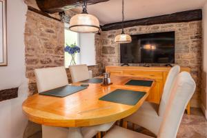 Spacious, luxury town centre Granary conversion في ستامفورد: غرفة طعام مع طاولة وكراسي خشبية