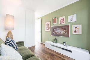 a living room with a green wall and a couch at 200 qm schwimmendes Penthouse in Vieregge