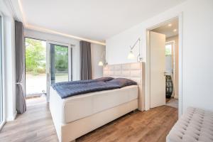 a white bedroom with a large bed and a window at 200 qm schwimmendes Penthouse in Vieregge