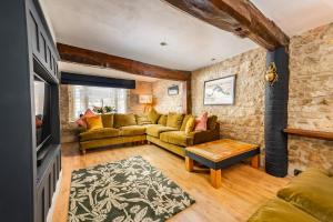 uma sala de estar com um sofá e uma mesa em Spacious, luxury town centre Granary conversion em Stamford