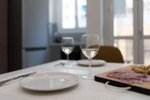 - une table avec deux verres de vin et une assiette de nourriture dans l'établissement Appartamento Santa Rita - STADIO & PALA OLIMPICO INALPI ARENA, à Turin