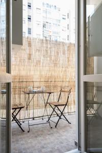 - une table et des chaises dans une chambre avec fenêtre dans l'établissement Appartamento Santa Rita - STADIO & PALA OLIMPICO INALPI ARENA, à Turin